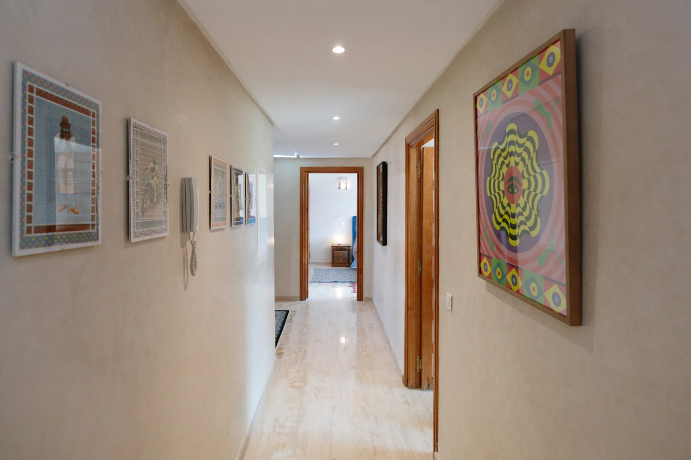 Hallway lined with framed artworks in Villa des Arts